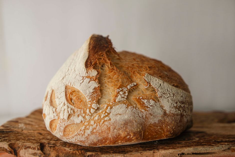 Close-up of freshly baked artisan sourdough bread on a rustic wooden board.